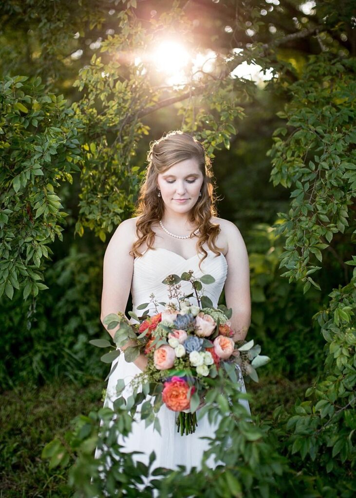 A bride holding a luscious bouquet of flowers.